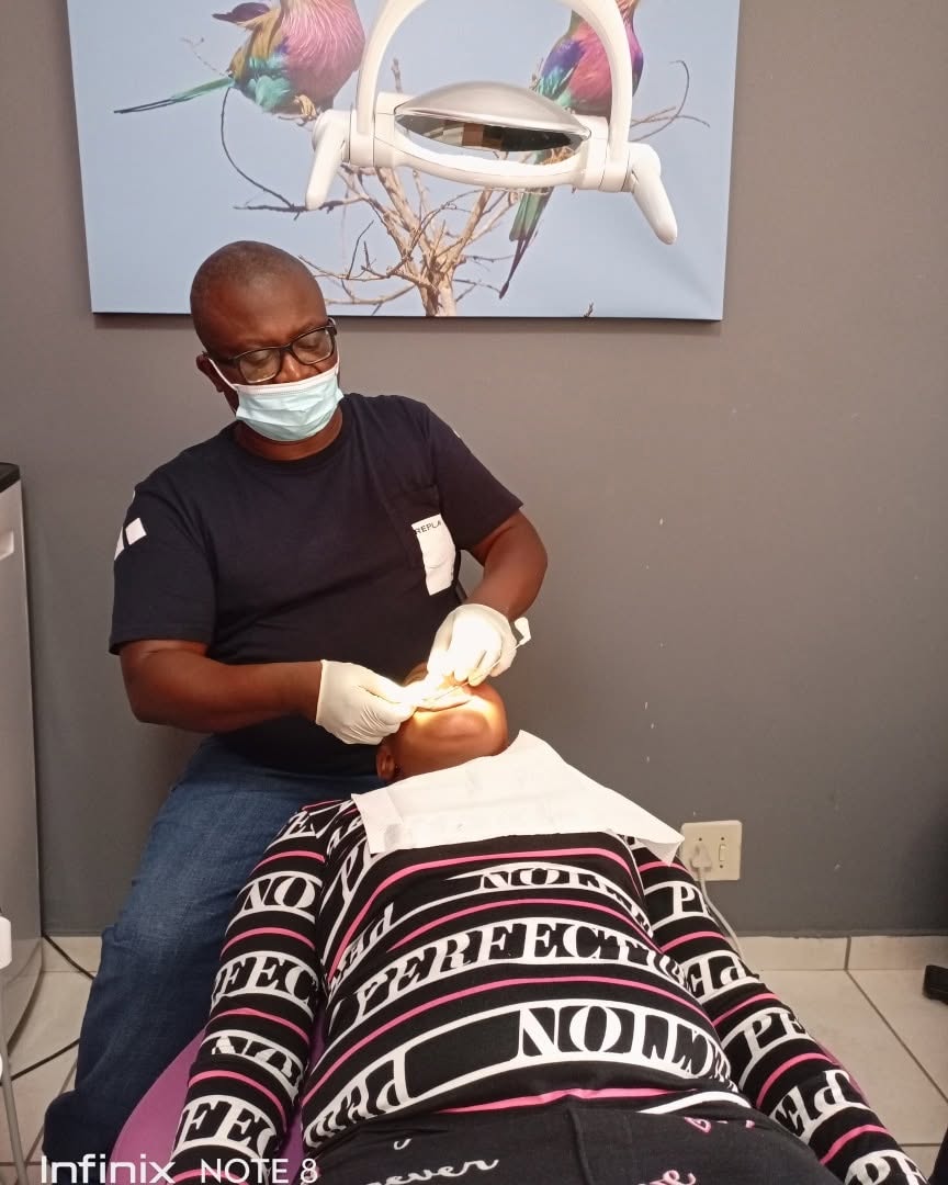 Dr Kutumela examining a patient's teeth during a treatment session